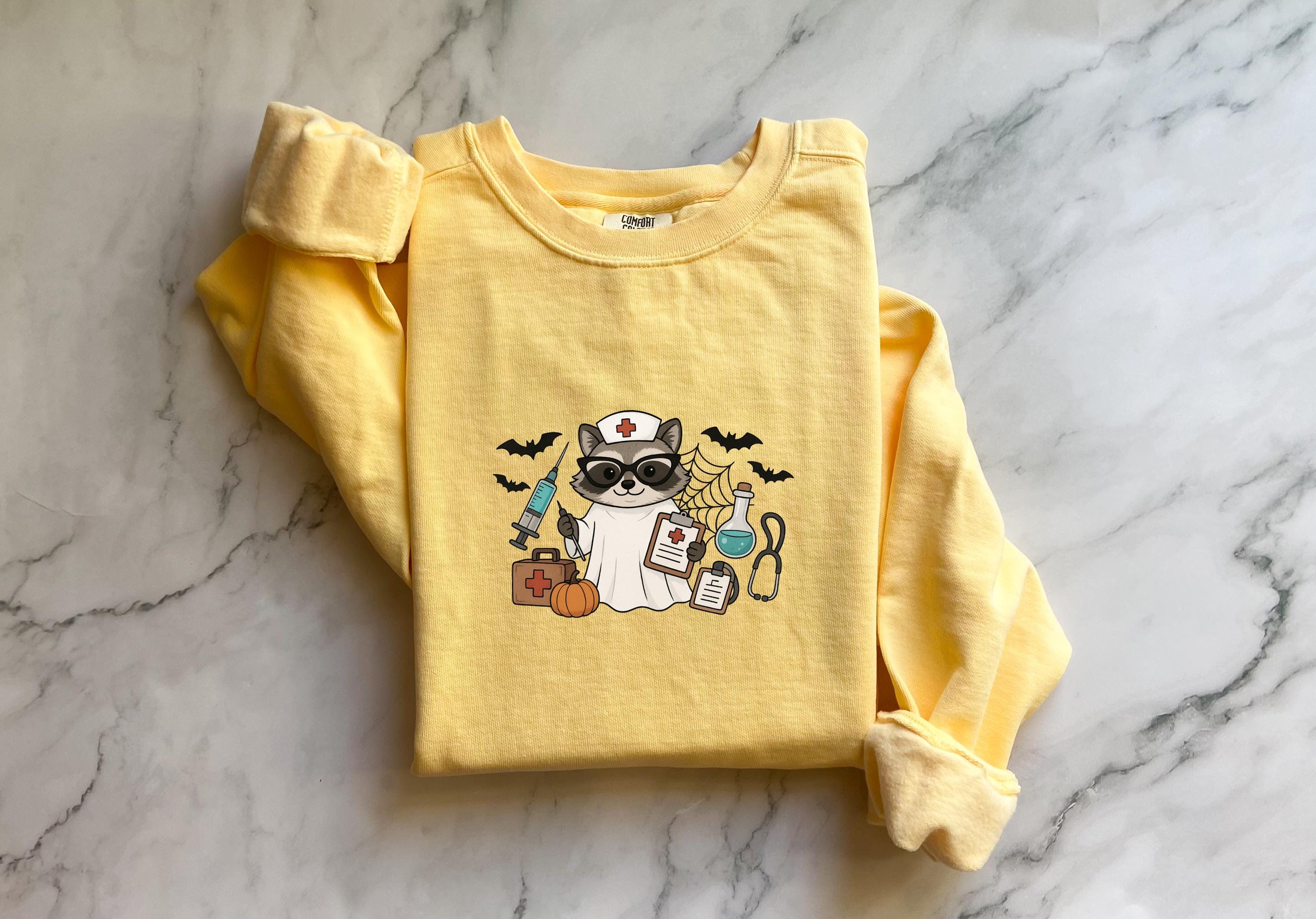 Raccoon Nurse Halloween Sweatshirt, Spooky RN Fall Top, Funny Cozy Autumn Pullover, Cute Retro Gift for Nurse